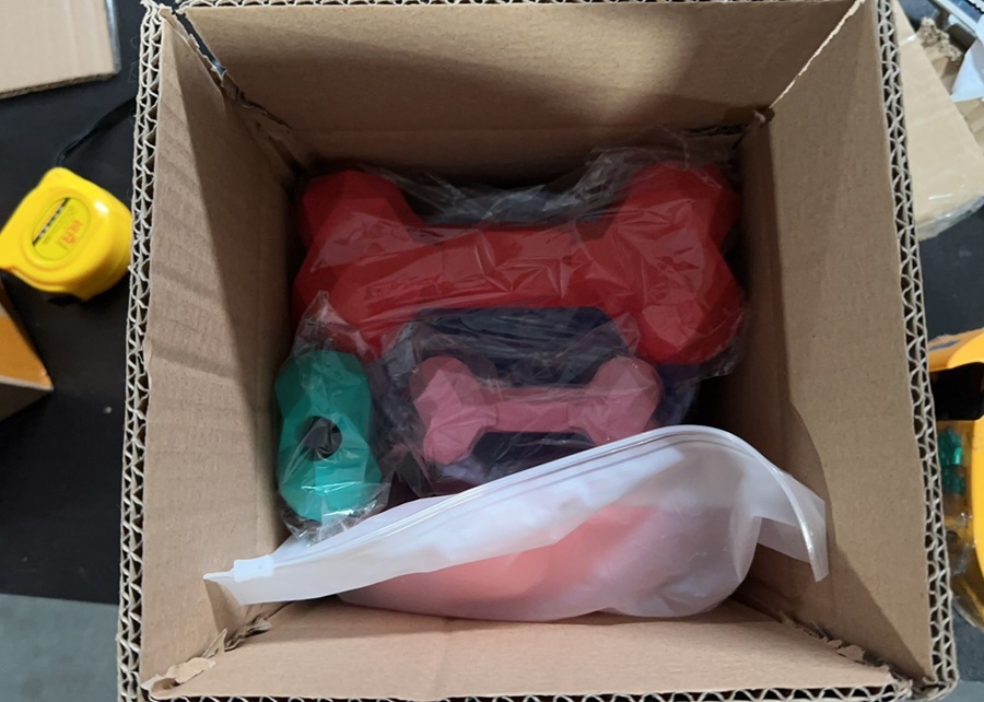 A person unboxing and inspecting a sample dog toy