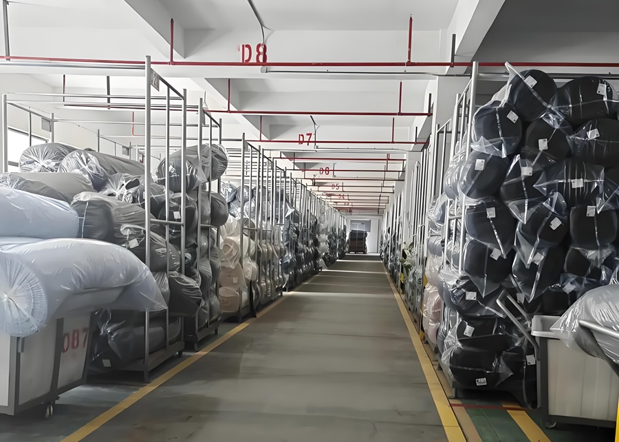 Rolls of fabric and materials for dog toy production in a warehouse.