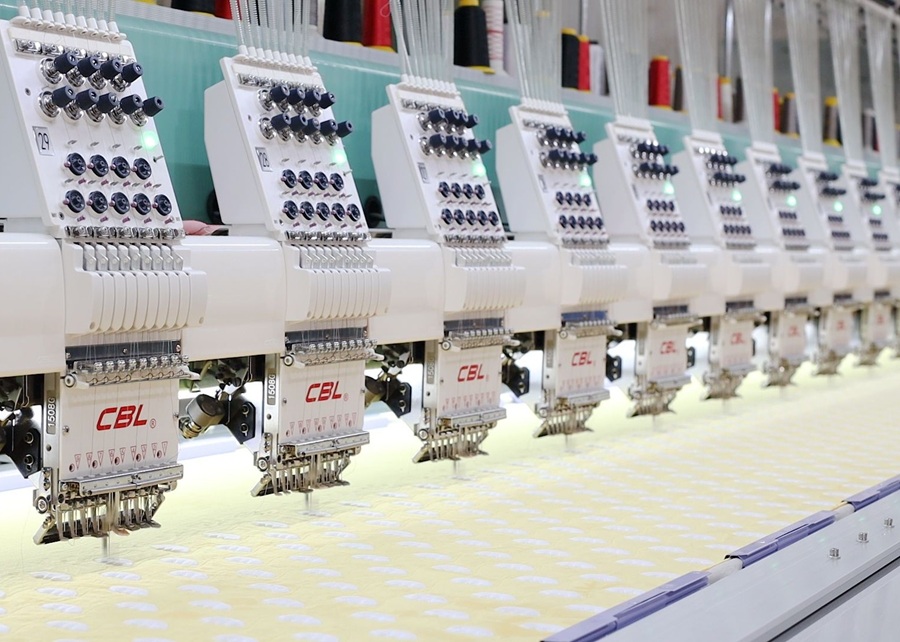 A computerized embroidery machine stitching a logo onto a dog toy.