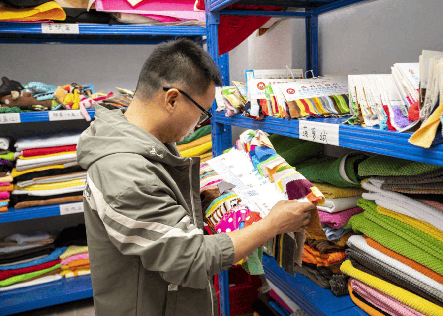 A display of various pet-safe fabrics and materials like TPR rubber, Oxford cloth, and canvas.