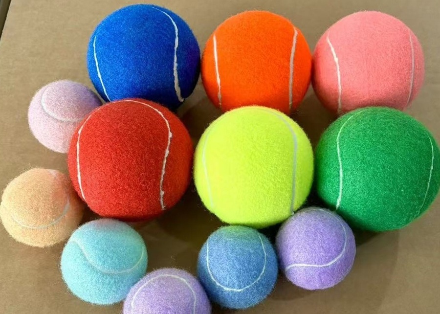 Different sized dogs playing with appropriately sized tennis balls.