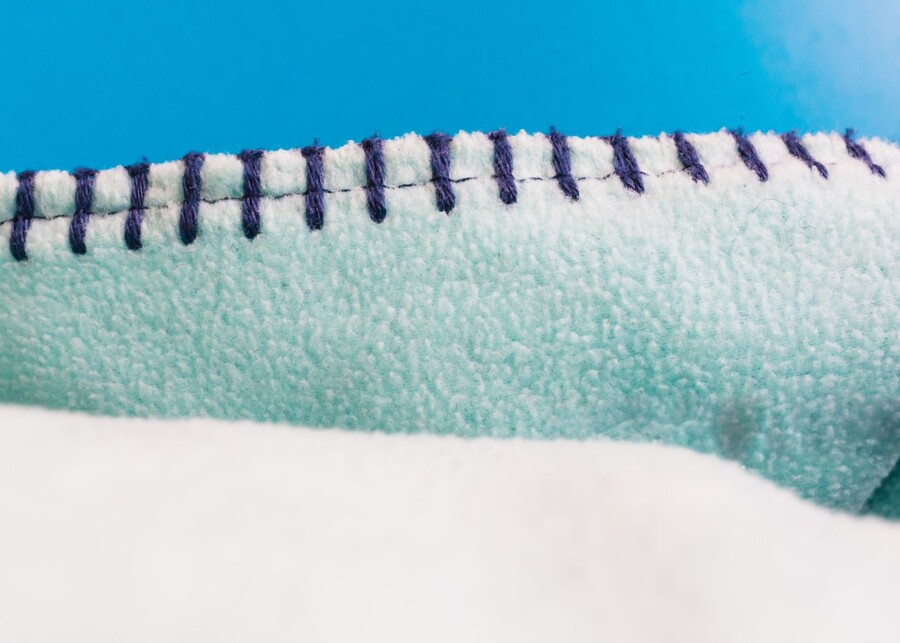 A close-up photo showing the reinforced, double-stitched seam on a plush dog toy.