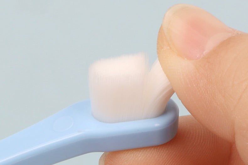 Close up of soft tapered bristles on dog toothbrush