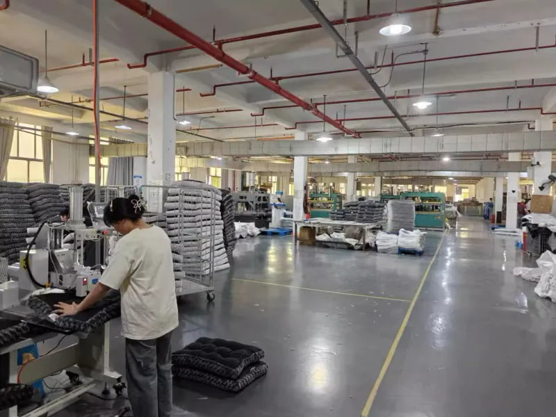 Worker sewing pet bed fabric in a production workshop