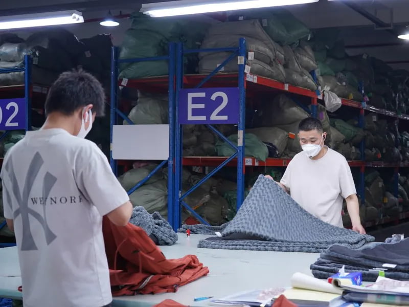 Workers checking textured fabric in a pet home products workshop