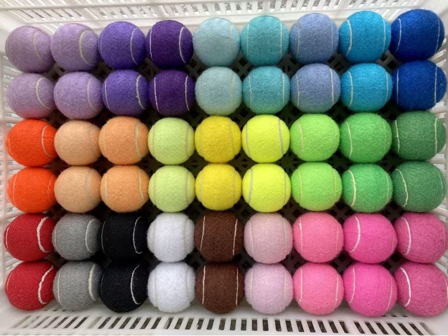 Assorted unbranded dog tennis balls arranged in a stock basket