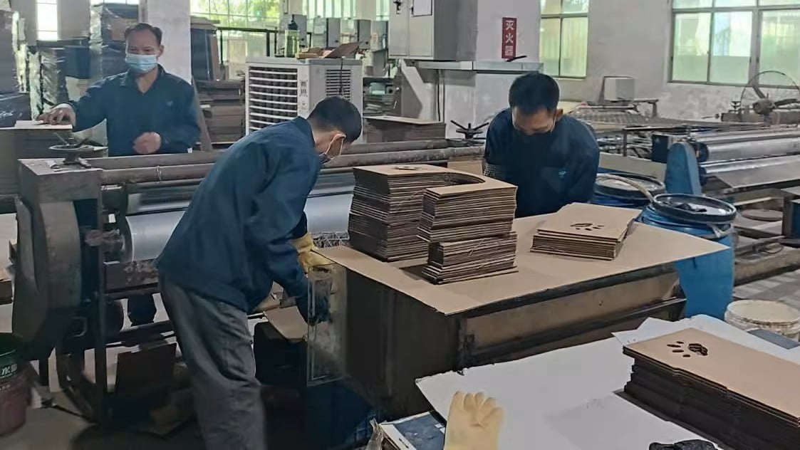 Workers finishing and inspecting cut components during cat scratcher production