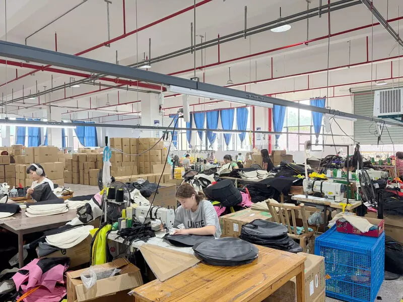 Workers sewing textile pet product components in a factory workshop