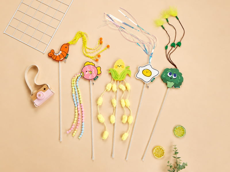 Assorted cat wand and teaser toys with rods, strings, feathers, and plush attachments