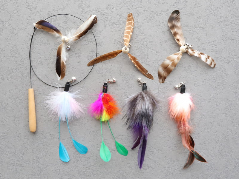 Assorted feather cat toys including feather balls, mice, and wand attachments