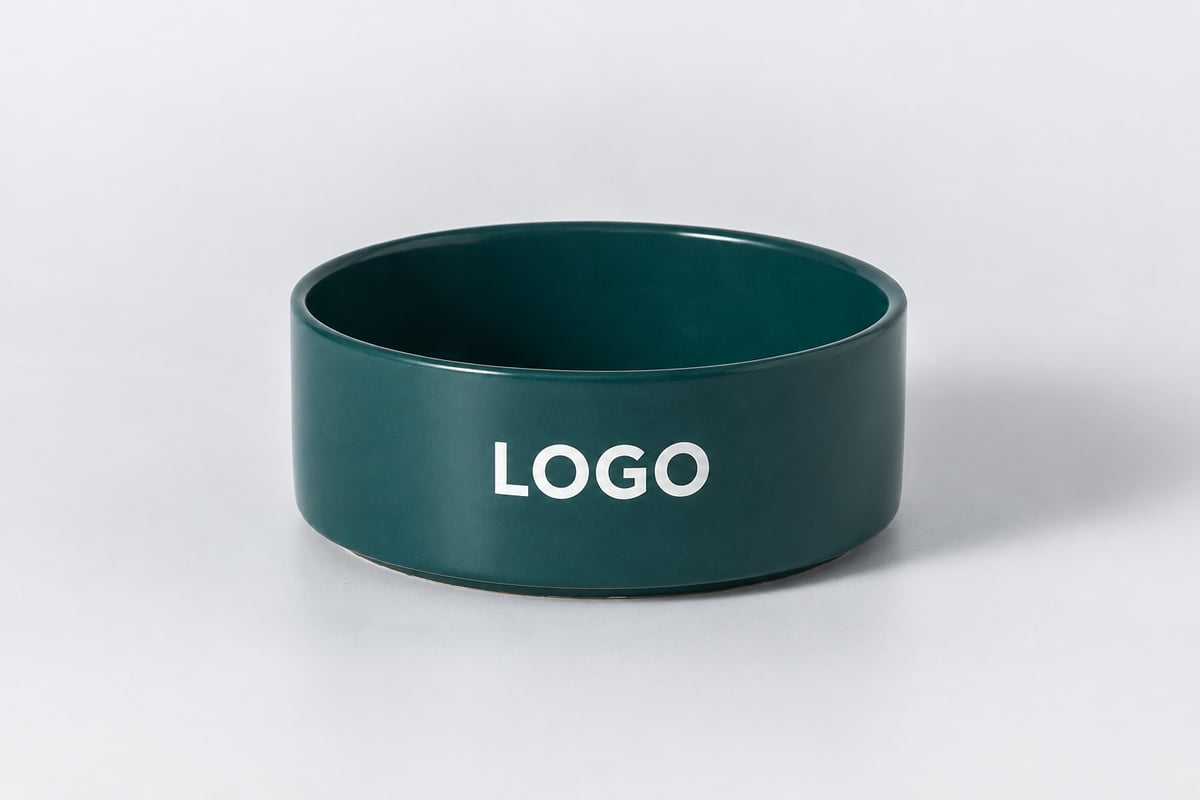 Dark teal ceramic pet bowl with white LOGO lettering as a logo placement example