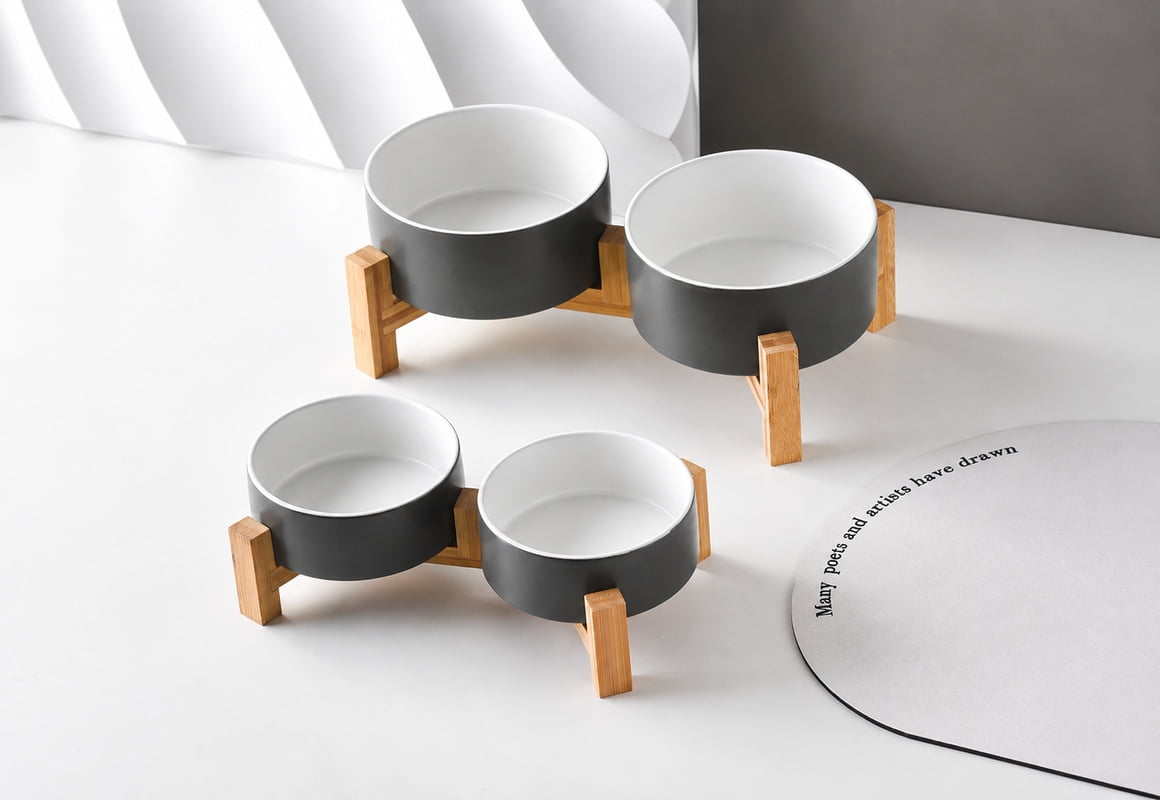 Two sizes of double ceramic pet bowl sets with charcoal exteriors, white interiors and wooden stands