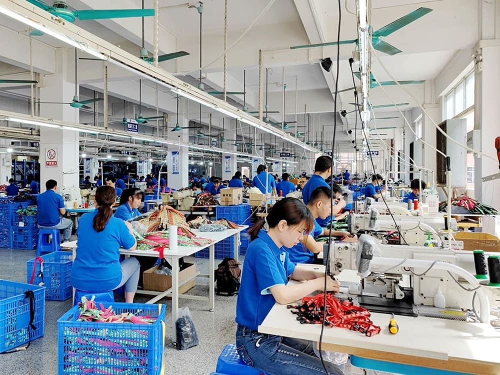 Workers sewing and assembling straps in a pet collar production workshop