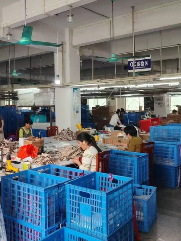 Workers inspecting straps and assembled products at quality control tables