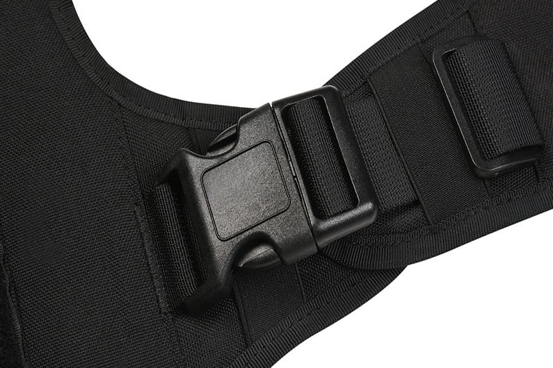 Close-up of black webbing threaded through a plastic side-release buckle and strap adjuster on a pet harness.