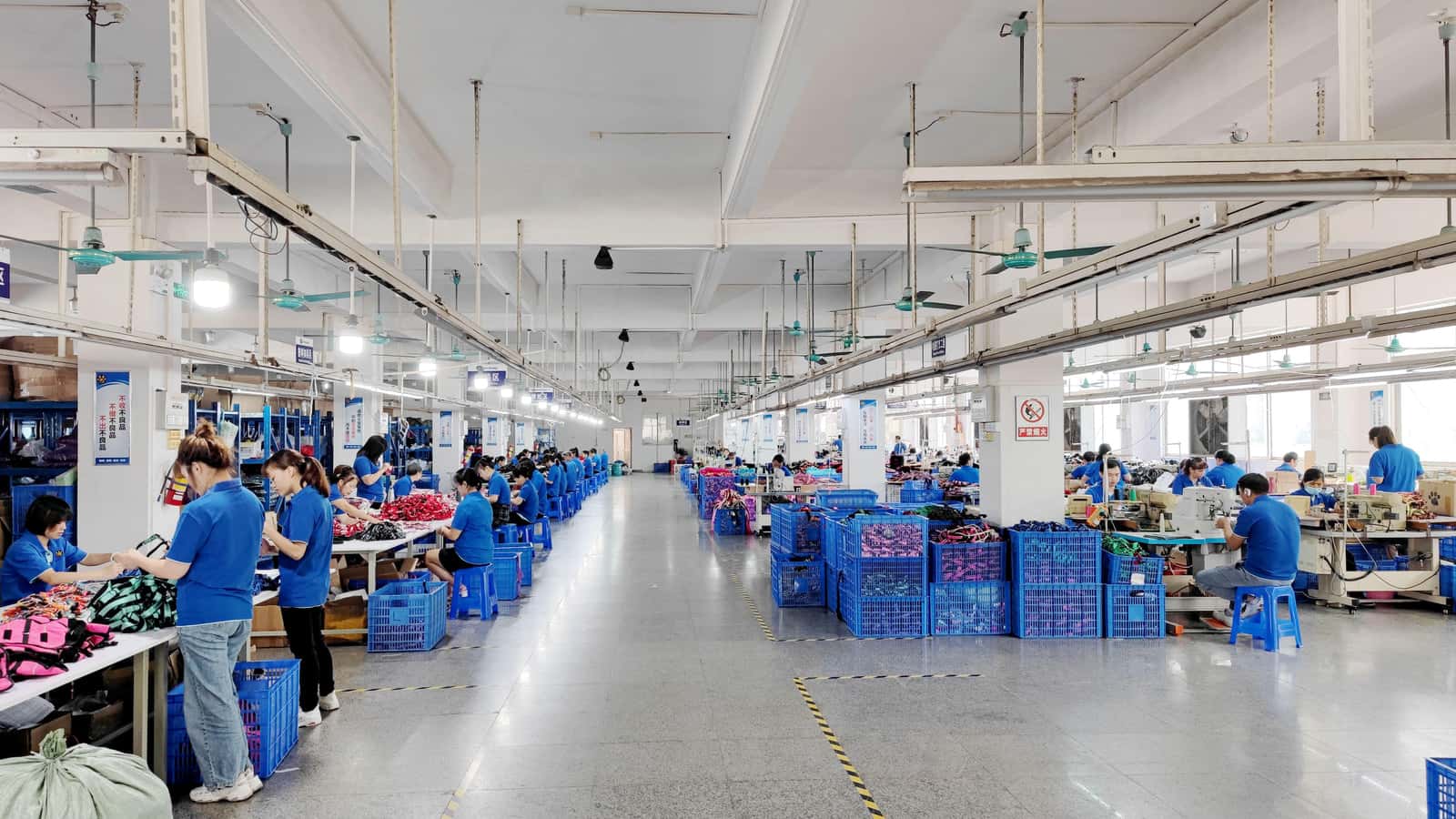 Preeminent production workshop with workers, sewing stations and bins of pet walking products