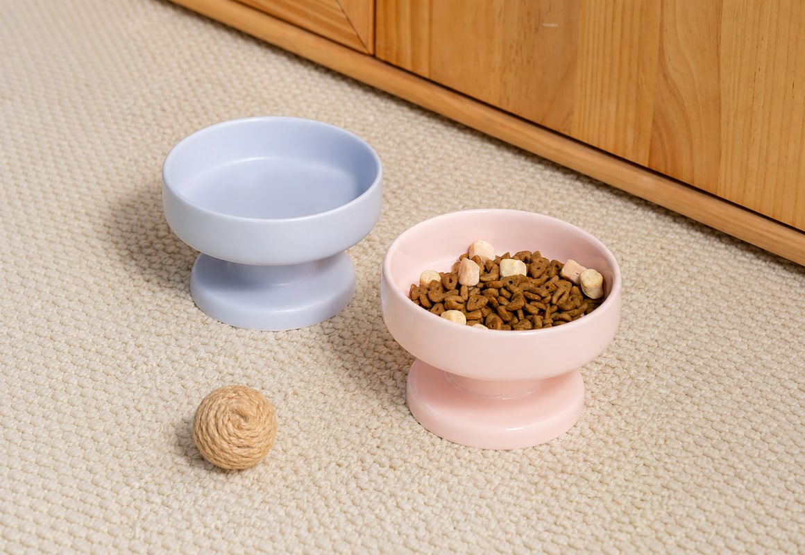 Pale blue and pink ceramic pet bowls with integrated raised pedestal bases