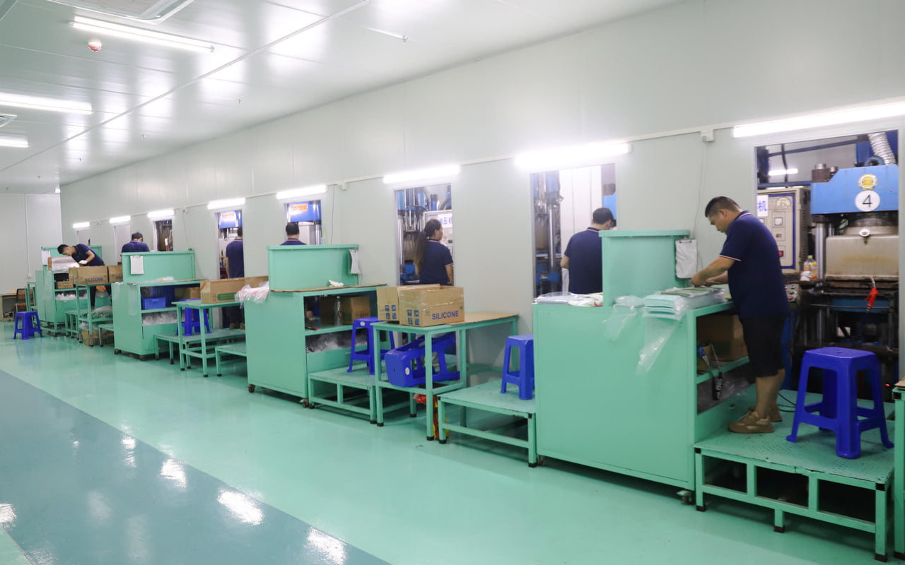 Production floor at a silicone pet bowl manufacturer, with workers operating molding equipment